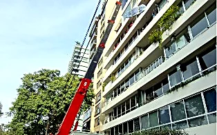 Grúa izando muebles en edificio
